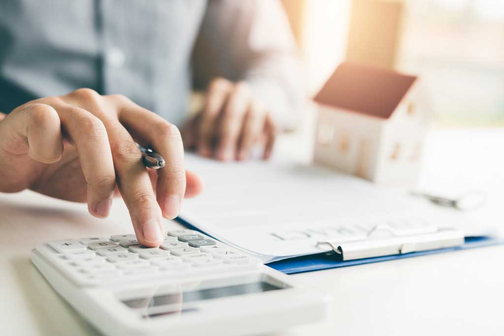 Image of someone using a calculator to portray how to calculate capital gains and capital gain tax on Canadian properties.